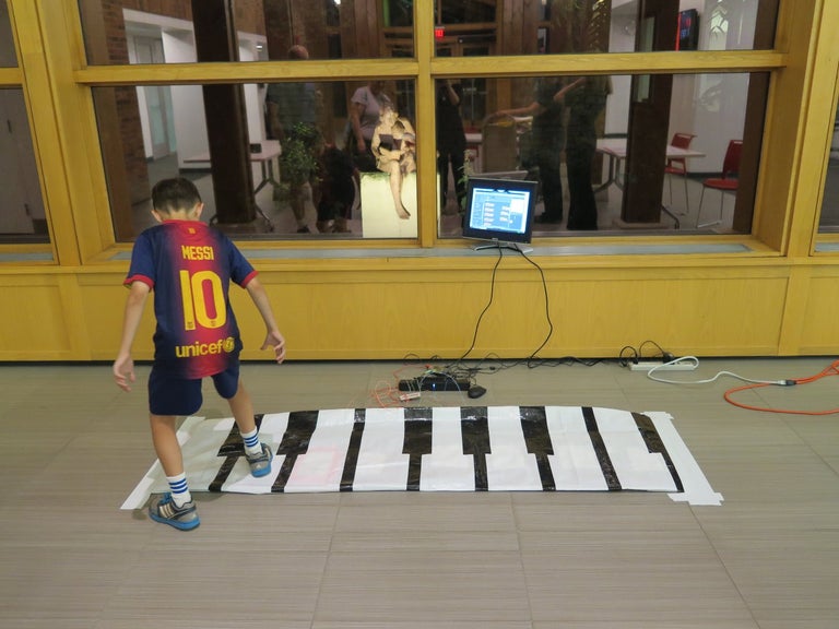 Enfant joue sur grand tapis piano