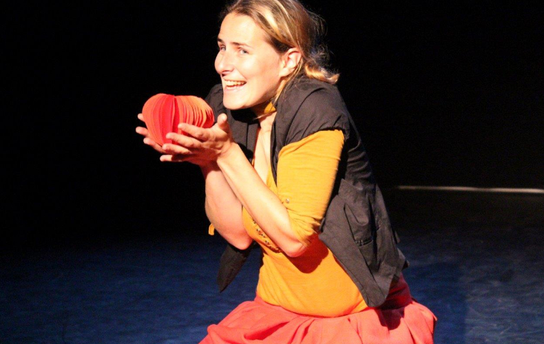 Une comédienne avec une pomme en papier dans les mains