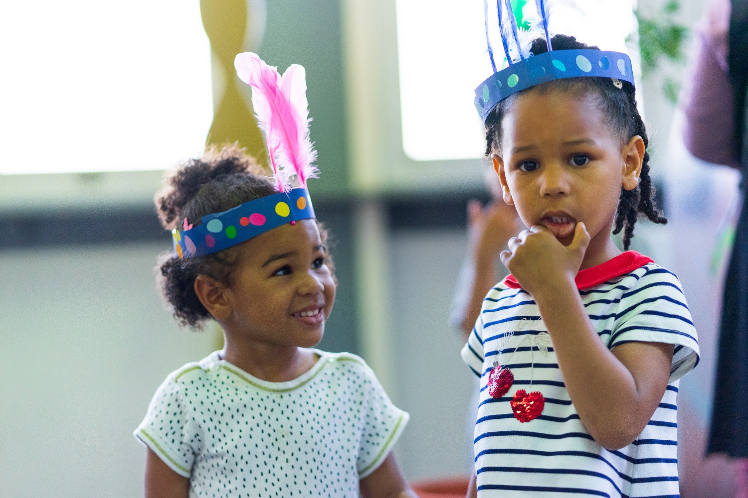 2 petites filles avec une couronne de plumes