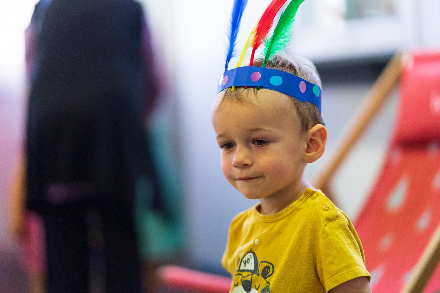 Un petit garçon avec une couronne de plumes