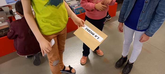 enfant qui tient une enveloppe dans sa main