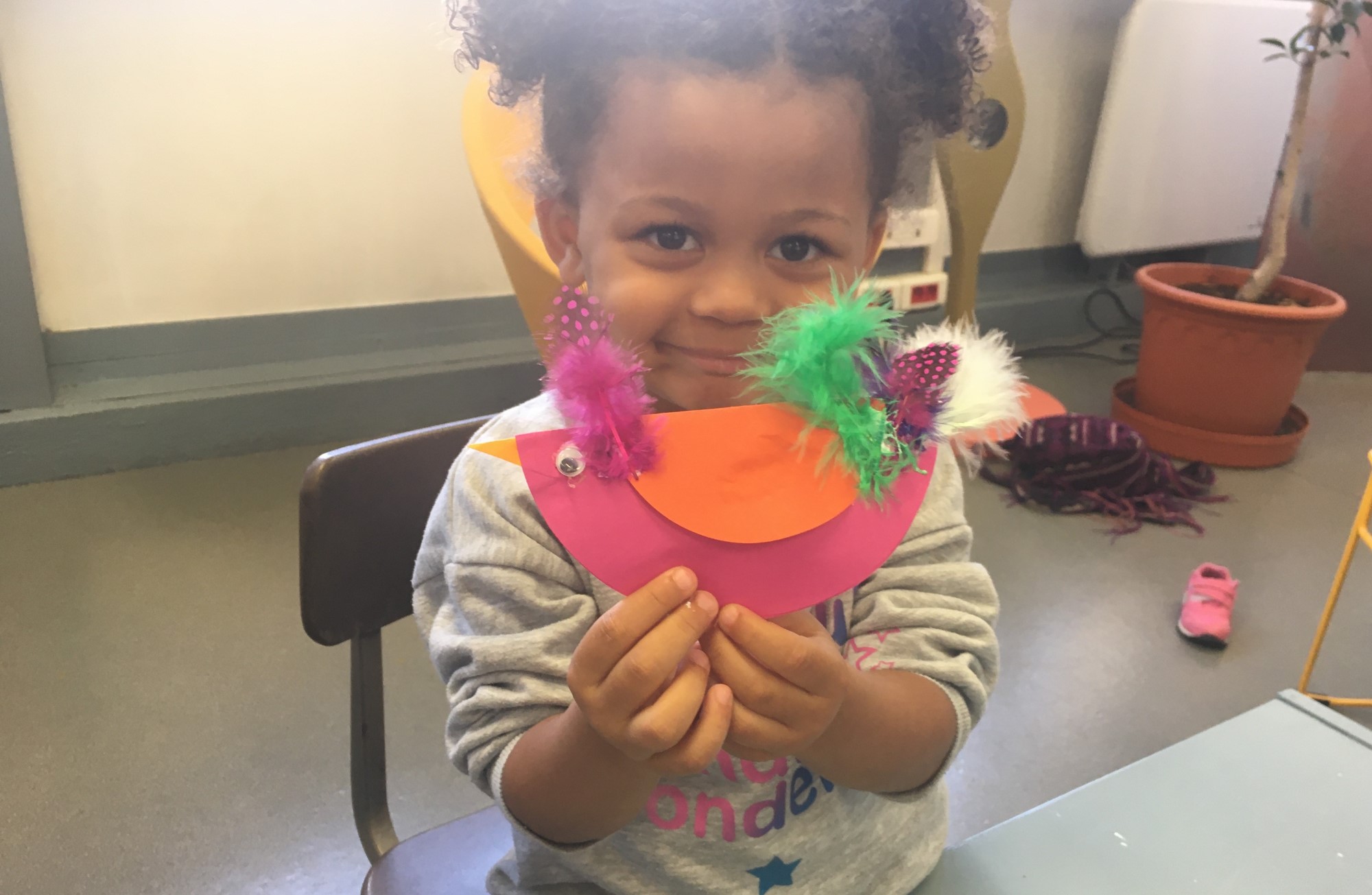 petite fille qui tient un oiseau en papier