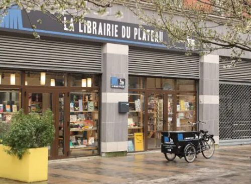 photo devanture librairie du Plateau avec le triporteur garé devant.