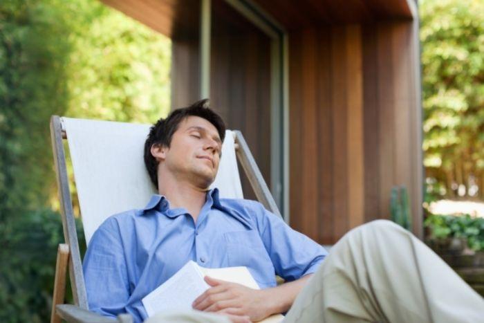 un homme entrain de dormir avec un livre sur le ventre