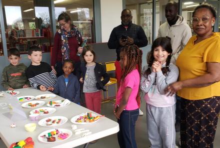 Enfants et adultes devant un buffet de mignardises en pâte à modeler